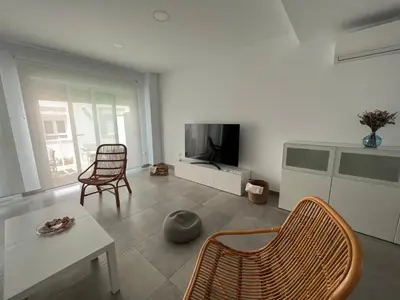 a living room with a television and a table and chairs at La casa de Pepo in Conil de la Frontera