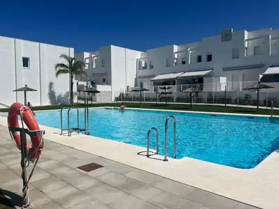 a large swimming pool in front of a building at La casa de Pepo in Conil de la Frontera
