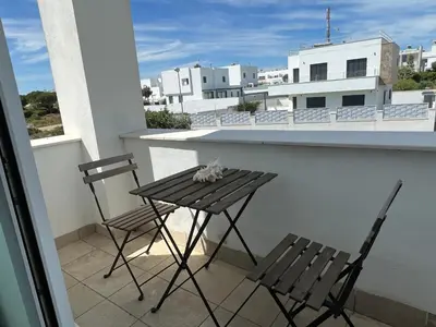 a small table and two chairs on a balcony at La casa de Pepo in Conil de la Frontera