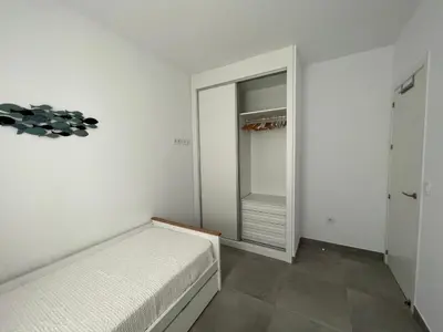 a white bedroom with a bed and a closet at La casa de Pepo in Conil de la Frontera