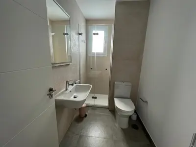 a white bathroom with a sink and a toilet at La casa de Pepo in Conil de la Frontera