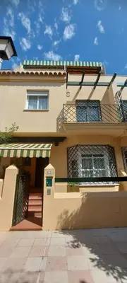 a building with awnings and a porch on it at Casa Carmen in Sanlúcar de Barrameda