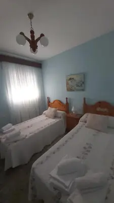 a bedroom with two beds and a ceiling fan at Casa Carmen in Sanlúcar de Barrameda