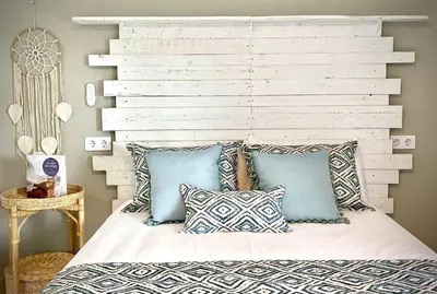 a bedroom with a white headboard and pillows on a bed at MyChoice Alegria in Rota