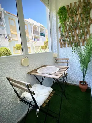 a table and chairs on a balcony with a window at MyChoice Alegria in Rota