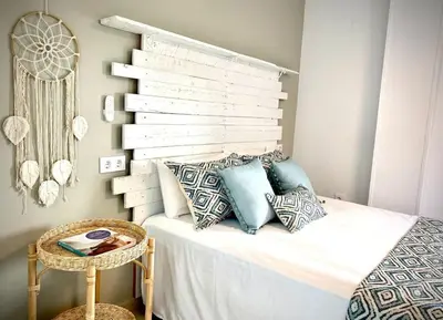 a bedroom with a white bed with pillows and a table at MyChoice Alegria in Rota