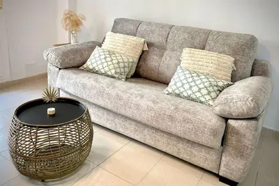 a couch with pillows and a table in a living room at MyChoice Alegria in Rota
