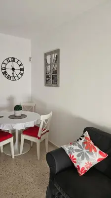 a living room with a table and a clock on the wall at SOL Y PLAYA in San Fernando