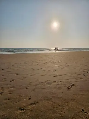 two people standing on a beach with the ocean at SOL Y PLAYA in San Fernando
