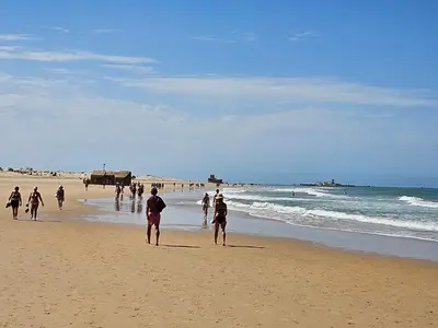 a group of people walking on the beach at SOL Y PLAYA in San Fernando