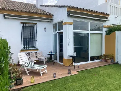 a patio with a chair and a table in a yard at Casa Pio Pio in Novo Sancti Petri
