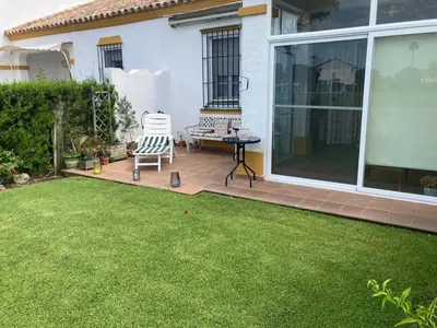 a patio with a chair and a table in a yard at Casa Pio Pio in Novo Sancti Petri