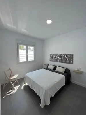 a bedroom with a bed and a chair in it at GRANIZO B in Chiclana de la Frontera