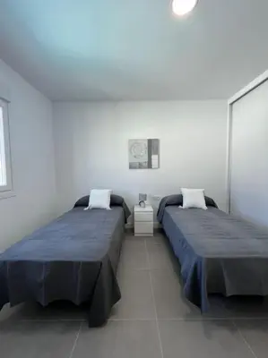 two beds sitting next to each other in a room at GRANIZO B in Chiclana de la Frontera