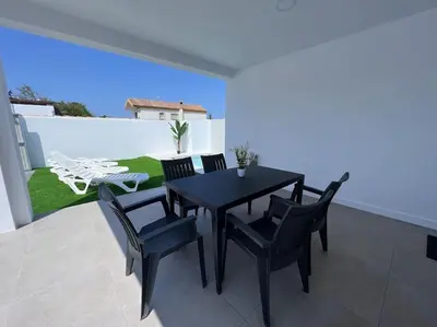 a black dining table and chairs on a patio at GRANIZO B in Chiclana de la Frontera