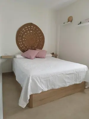 a bedroom with a white bed with pink pillows at Apartamento en Jerez 3 dormitorios y 2 baños in Jerez de la Frontera