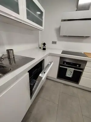 a kitchen with white cabinets and an oven at Apartamento en Jerez 3 dormitorios y 2 baños in Jerez de la Frontera