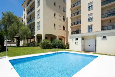 a swimming pool in front of a building at Apartoyou - Soto de Vistahermosa in El Puerto de Santa María
