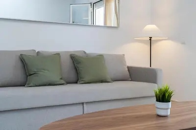 a living room with a gray couch with green pillows at Apartoyou - Soto de Vistahermosa in El Puerto de Santa María