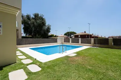 a swimming pool in a yard next to a house at Apartoyou - Soto de Vistahermosa in El Puerto de Santa María