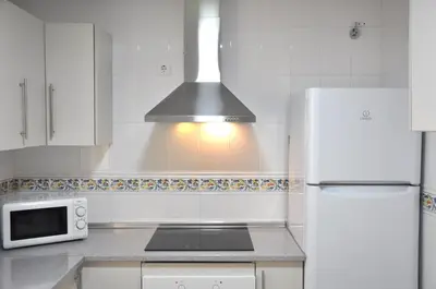 a kitchen with a white refrigerator and a microwave at Apartamento Jilguero con parking individual privado in Sanlúcar de Barrameda