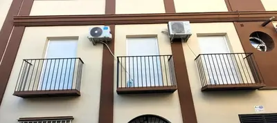 a building with balconies and a camera on it at Apartamento Jilguero con parking individual privado in Sanlúcar de Barrameda