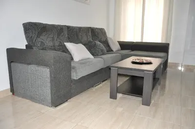 a living room with a couch and a coffee table at Apartamento Jilguero con parking individual privado in Sanlúcar de Barrameda