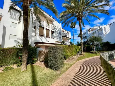 a building with palm trees next to a sidewalk at costa ballena elite in Costa Ballena