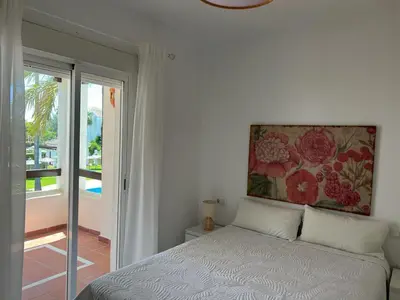 a bedroom with a bed and a painting on the wall at costa ballena elite in Costa Ballena