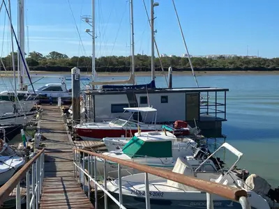 a group of boats docked at a dock in the water at Houseboat Cádiz El Puerto - Casa Flotante in El Puerto de Santa María