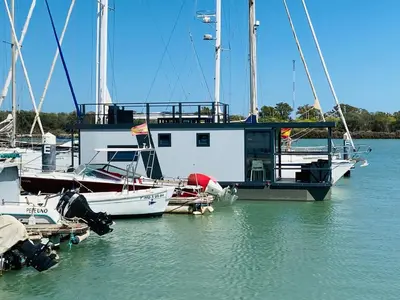 a group of boats are docked in the water at Houseboat Cádiz El Puerto - Casa Flotante in El Puerto de Santa María