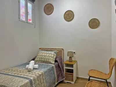 a bedroom with a bed and a chair at Apartamento J Burgos - Ole Solutions in El Puerto de Santa María