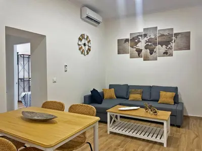 a living room with a blue couch and a table at Apartamento J Burgos - Ole Solutions in El Puerto de Santa María