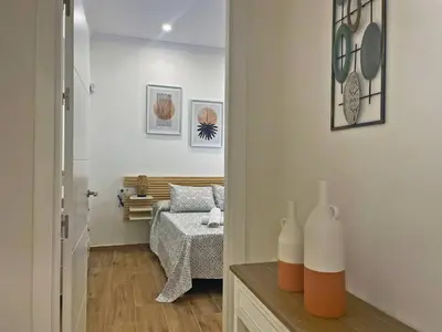a room with a bedroom with a bed and a mirror at Apartamento J Burgos - Ole Solutions in El Puerto de Santa María