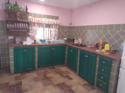 a kitchen with green cabinets and a tile floor at Almajar 4 in El Puerto de Santa María