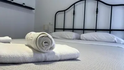 a couple of beds with towels on the floor at Gades de la Caleta con Terraza Grupo AC Gestion in Cádiz