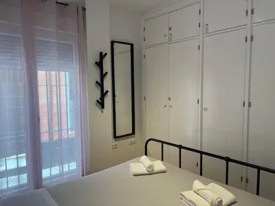 a bedroom with a bed and a mirror and a window at Gades de la Caleta con Terraza Grupo AC Gestion in Cádiz