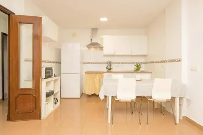 a kitchen with a table and some white cabinets at Villa Lola in Cádiz