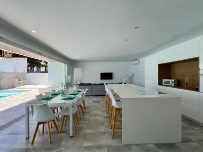 a kitchen and dining room with a table and chairs at Casa El Azul in Chiclana de la Frontera