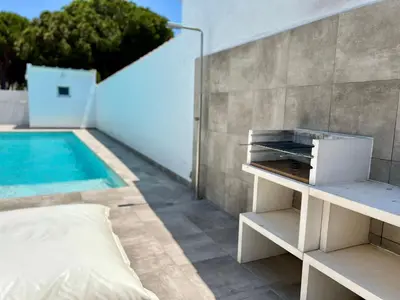 a bedroom with a bed next to a swimming pool at Casa El Azul in Chiclana de la Frontera