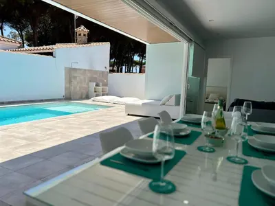 a dining room with a table and a swimming pool at Casa El Azul in Chiclana de la Frontera