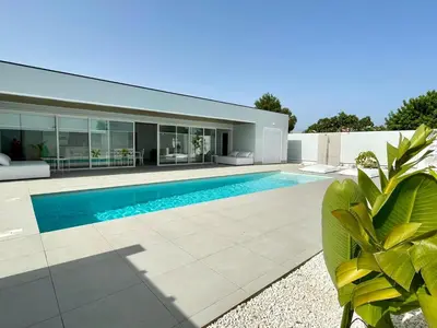 a swimming pool in the backyard of a house at Chalet El Eden in Chiclana de la Frontera