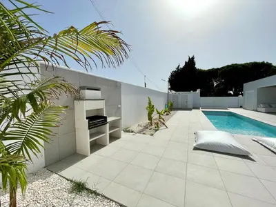 a patio with a swimming pool next to a house at Chalet El Eden in Chiclana de la Frontera