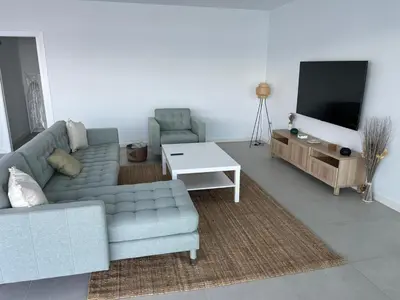 a living room with a couch and a tv at Chalet El Eden in Chiclana de la Frontera