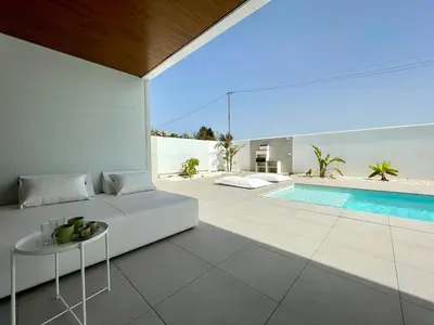 a living room with a white couch and a swimming pool at Chalet El Eden in Chiclana de la Frontera