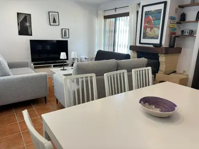 a living room with a table and a couch at Chalet Urb Doña Violeta 500m Mar in Chiclana de la Frontera