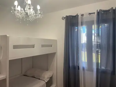 a bedroom with a bunk bed with a chandelier at Chalet Urb Doña Violeta 500m Mar in Chiclana de la Frontera