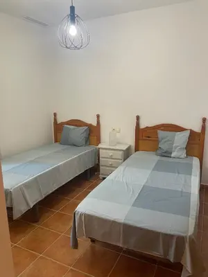 two beds sitting next to each other in a room at Chalet Urb Doña Violeta 500m Mar in Chiclana de la Frontera