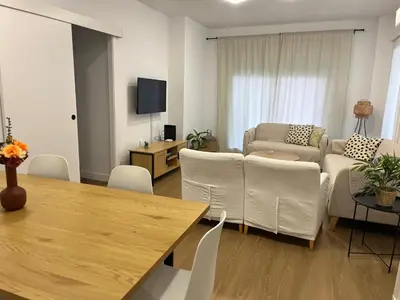a living room with a couch and a table and chairs at Apartamento Vista Bahia - Vistahermosa in El Puerto de Santa María