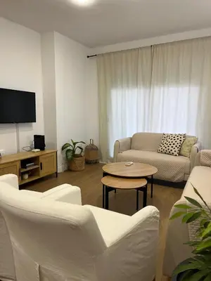 a living room with white furniture and a flat screen tv at Apartamento Vista Bahia - Vistahermosa in El Puerto de Santa María